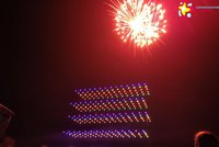Die Drohnen als kleine Punkte am Nachthimmel, darüber Feuerwerk.