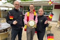 Johannes Wiethoff mit Fußball, Heiner Torweihen und Yildiz Yanik mit kleinen Deutschland-Fähnchen vor der Gastrnomie Rietbik.
