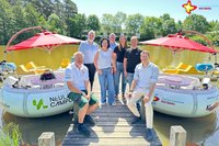 Sponsoren und Gartenschaupark-Vertreter auf dem Steg am Obersee, an dem rechts und links die BBQ-Boote festgemacht sind.