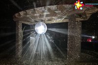 Eine Discokugel wird mit Laser angestrahlt.