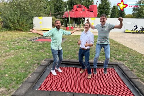 Vertreter der beiden Sponsoren und Gartenschaupark-Geschäftsführer hüpfen auf einem der neuen Trampoline.