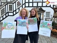 Elke Milsch und Jessica Meier Degener mit den neuen Kalendern vor dem Rathaus.