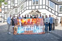 Organisatoren und Sponsoren vor dem Rietberger Rathaus mit einem großen "Friedas Tanztee"-Banner in der Hand.