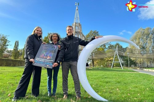 Organisatoren von Gartenschaupark und Flash Art mit großem Halbmond und Traumpfade-Plakat vor dem Rutschenturm im Gartenschaupark.