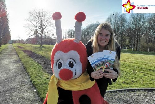Maskottchen Rieti und Gartenschaupark-Mitarbeiterin Bianca Piekatz mit den neuen  Parkflyern im Gartenschaupark.