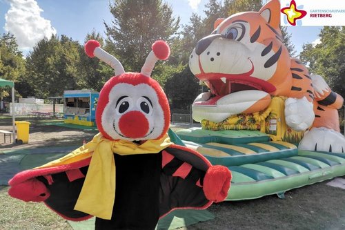 Maskottchen Rieti vor einer Hüpfburg in Form eines Tiger-Kopfes