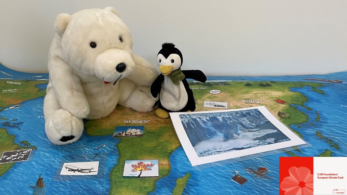 Ein Stofftier-Eisbär und ein Stofftier-Pinguin sitzen auf einer großen Landkarte. Vor sich haben sie Bilder von Flugzeugen, einen Kraftwerk und einem abbrechenden Eisberg.