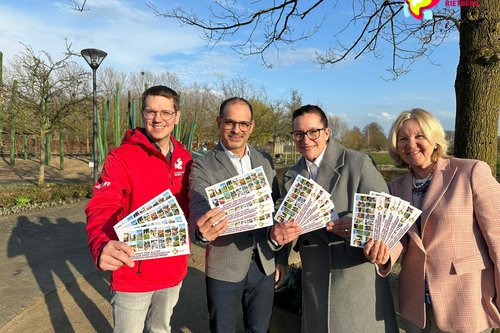 Gartenschaupark-Geschäftsführer und Vertreter der drei beteiligten Kliniken stehen vor dem Spielplatz Schilfwald und halten die Gutscheine für junge Familien in der Hand.