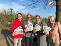 Gartenschaupark-Geschäftsführer und Vertreter der drei beteiligten Kliniken stehen vor dem Spielplatz Schilfwald und halten die Gutscheine für junge Familien in der Hand.