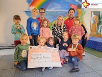 Die Kinder aus dem Kindergarten Regenbogen mit Organisatoren, Sponsor und Scheck.