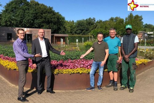 Vertreter von Sparkasse Gütersloh-Rietberg-Versmold, Förderverein und Gartenschaupark vor einem toll blühenden Blumenbeet.