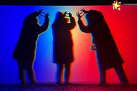 Drei Menschen stehen hinter der bunt beleuchteten Fotowand. Zu sehen sind nur ihre Silhouetten. Ihre Hände sind zu Herzen geformt.