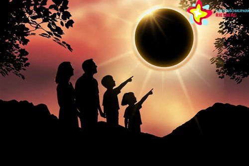 Das Symbolbild zeigt eine Sonnenfinsternis und Menschen, die sie sich ansehen.