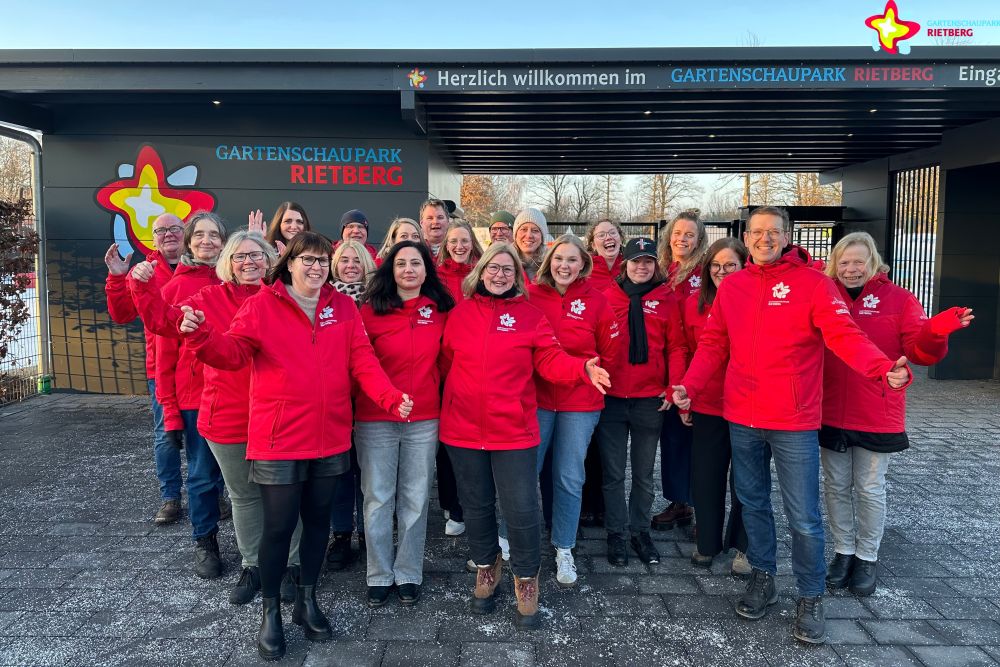 Das Gartenschaupark-Team steht vor dem neuen Kassenhäuschen. Alle tragen die rote Gartenschaupark-Dienstjacke.