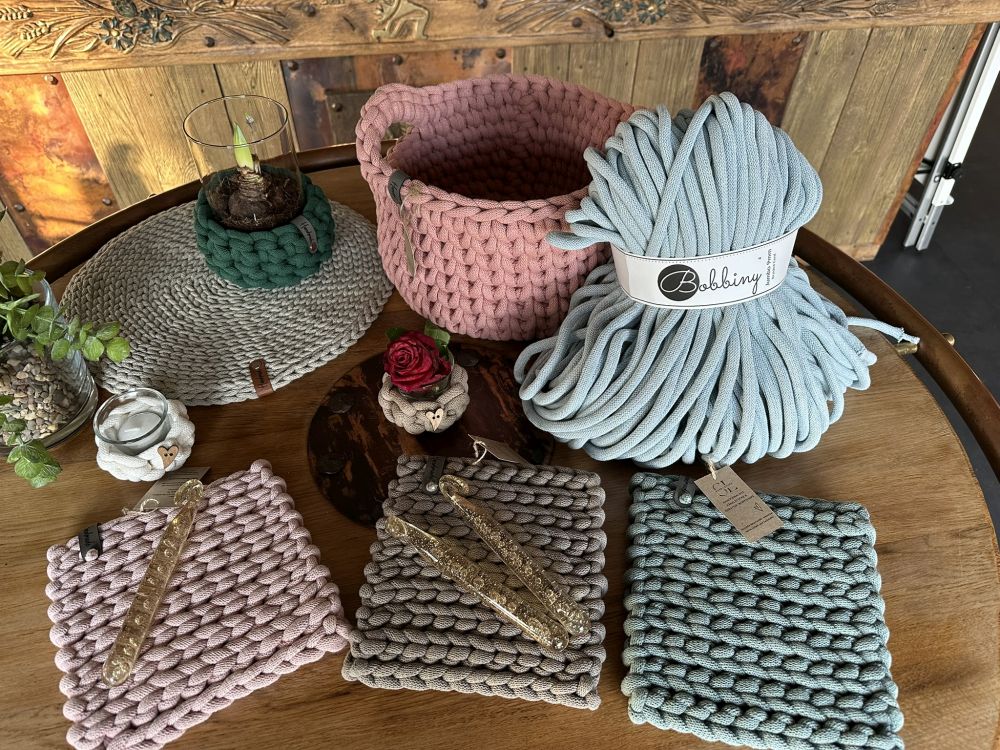 Gehäkelte Untersetzer, Flechtkordel und Häkelnadeln.