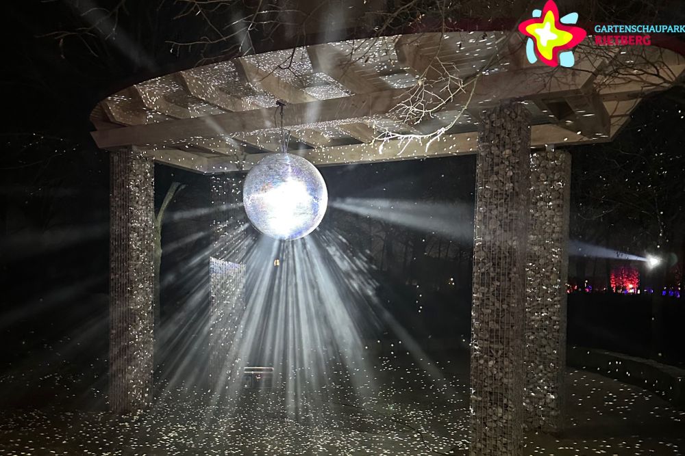 Eine Discokugel wird mit Laser angestrahlt.